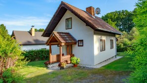 A single-story house with a sloped roof, a small porch with a wooden railing, and a satellite dish on the roof. - Žabovřesky by Interhome (Dehtáře)