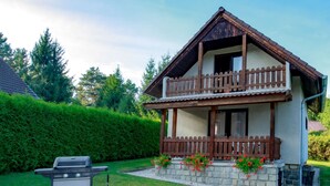 A two-story house with a balcony, a barbecue grill, and a stone foundation. - Žabovřesky by Interhome (Dehtáře)