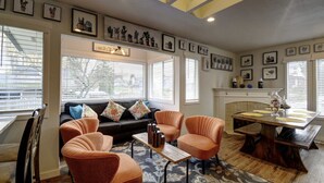 A living room with a sofa, two armchairs, a coffee table, and a fireplace. - Bright & Airy 4 Bedroom Villa in North Tacoma (Tacoma)