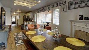 A spacious living area with a wooden dining table, yellow placemats, and a fireplace. - Bright & Airy 4 Bedroom Villa in North Tacoma (Tacoma)