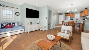 A modern living room with a sofa, coffee table, and dining area.