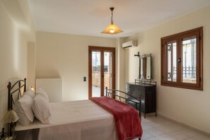 Une chambre à coucher avec un lit, une commode, un miroir et une fenêtre.