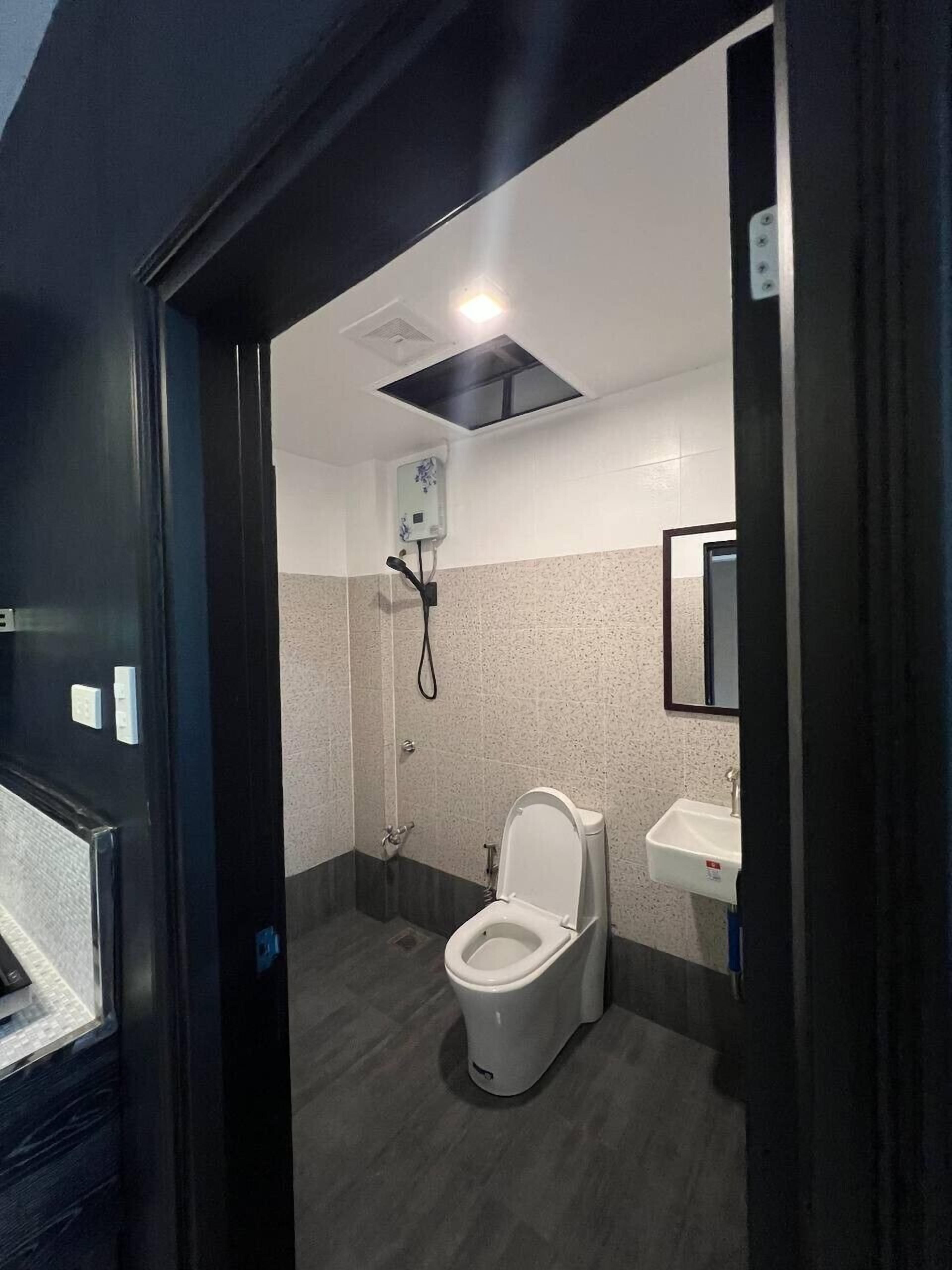 A modern bathroom with a toilet, sink, and shower.