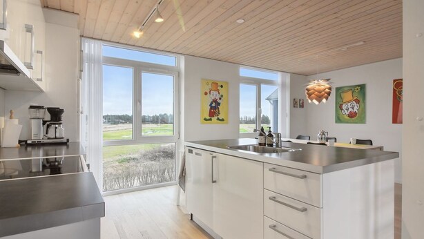 A modern kitchen with a large island, white cabinetry, and a view of the outdoors. - "Borica" - 700m from the sea by Interhome (Løkken)