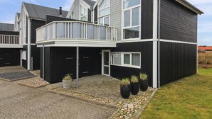 A modern two-story house with a balcony, a garage, and a well-maintained garden with potted plants. - "Borica" - 700m from the sea by Interhome (Løkken)
