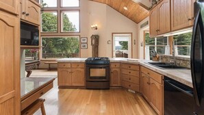 A kitchen with wooden cabinets, a stove, and a refrigerator. - Majestic Sequim Vacation Home near Sequim Bay (Sequim)