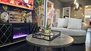 Una sala de estar moderna con chimenea, una mesa de centro redonda y un sofá.