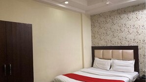 Un dormitorio con cama, armario y pared con estampado floral.
