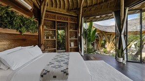 Un dormitorio amplio con una cama grande, paredes de madera y vistas al exterior.