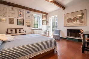 Un dormitorio con una cama grande, una chimenea y varias fotos enmarcadas en las paredes.