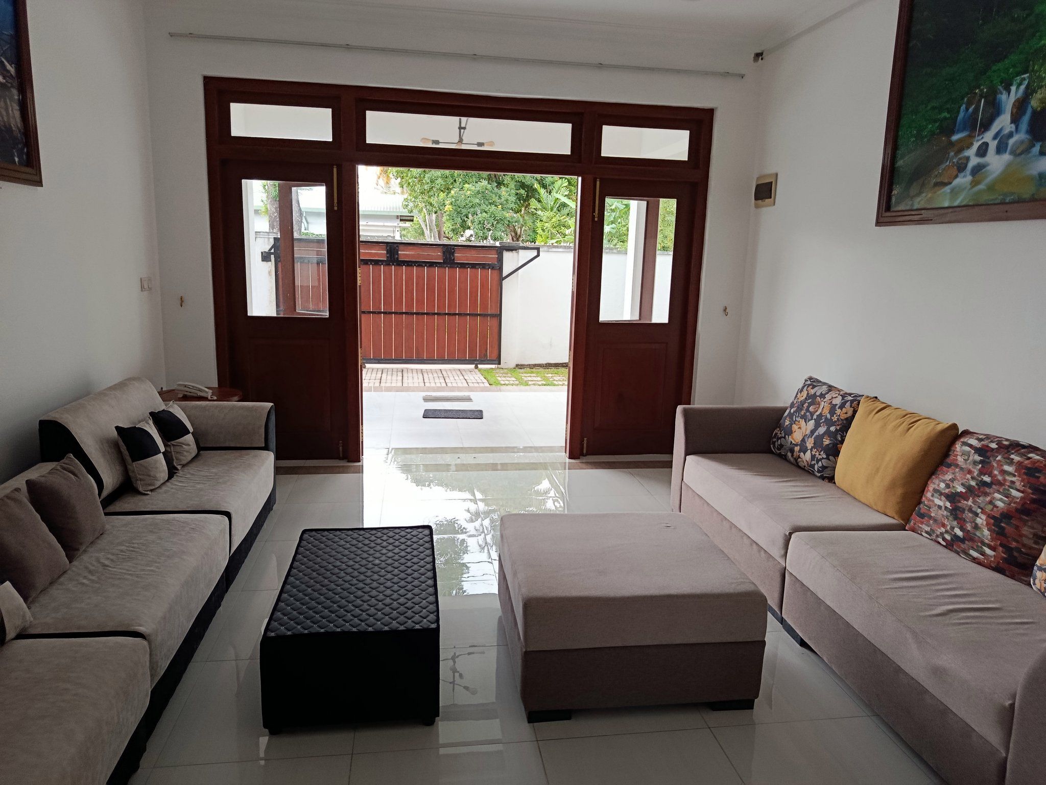 Sala de estar con dos sofás, una mesa de centro y vistas al exterior a través de un ventanal.
