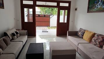 Sala de estar con dos sofás, una mesa de centro y vistas al exterior a través de un ventanal.