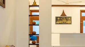 A modern living room with a sofa, a coffee table, and a decorative shelf with vases. - Piyum Villa Kosgoda (Kosgoda)