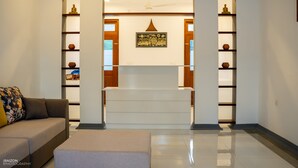 A modern living room with a sofa, a coffee table, and a decorative wall with shelves and a framed picture. - Piyum Villa Kosgoda (Kosgoda)