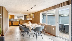 A modern kitchen with wooden cabinets and a dining area with a large table and chairs. - "Fidelia" - 400m from the sea by Interhome (Storvorde)