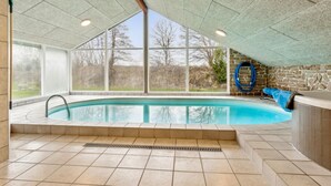 A swimming pool with a stone wall and a view of trees. - "Fidelia" - 400m from the sea by Interhome (Storvorde)