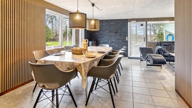 A modern dining area with a long table, multiple chairs, and pendant lighting. - "Fidelia" - 400m from the sea by Interhome (Storvorde)