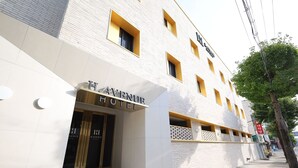 A modern hotel with a white facade and yellow accents. - H AVENUE  Jecheon Station (Jecheon)
