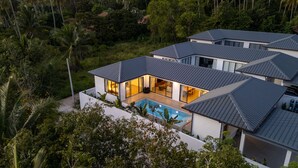 A modern multi-story house with a swimming pool, surrounded by lush greenery. - Modern 3 Bedroom Villa - KBR16 (Koh Samui)