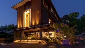 A modern building with a prominent vertical design, large windows, and a well-lit entrance area. - Tamana Onsen Kura no Sato (Tamana)
