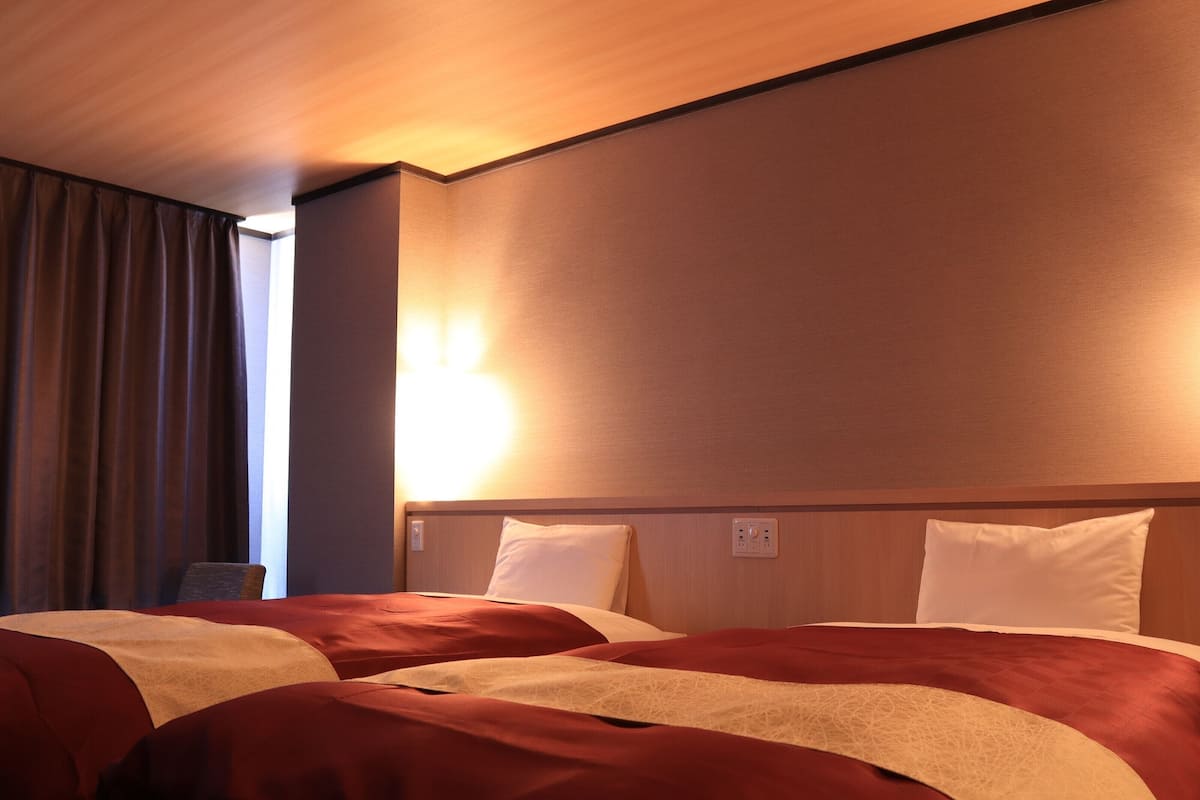 Ein Hotelzimmer mit einem großen Bett, einem Nachttisch und einer Wandlampe.