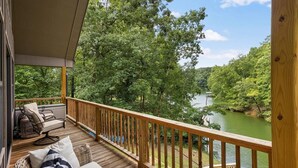 Una terraza de madera con vistas a un río y un bosque.