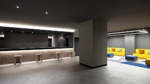 Um hall moderno com balcão de recepção, área de estar e um pilar grande.