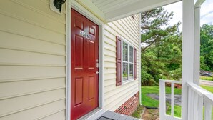 A house with a red door, number 2306, a porch with a white railing, and a green lawn. - * Prime Location: 2-BR Oasis with Washer & Dryer * (Richmond)