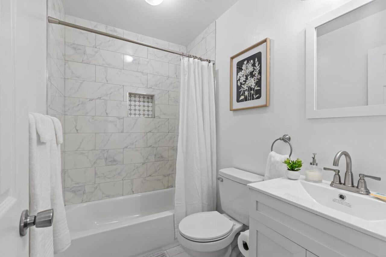 A modern bathroom with a bathtub, toilet, and sink.