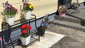 A balcony with potted plants and a small table. - Guest House MOMO (Obihiro)