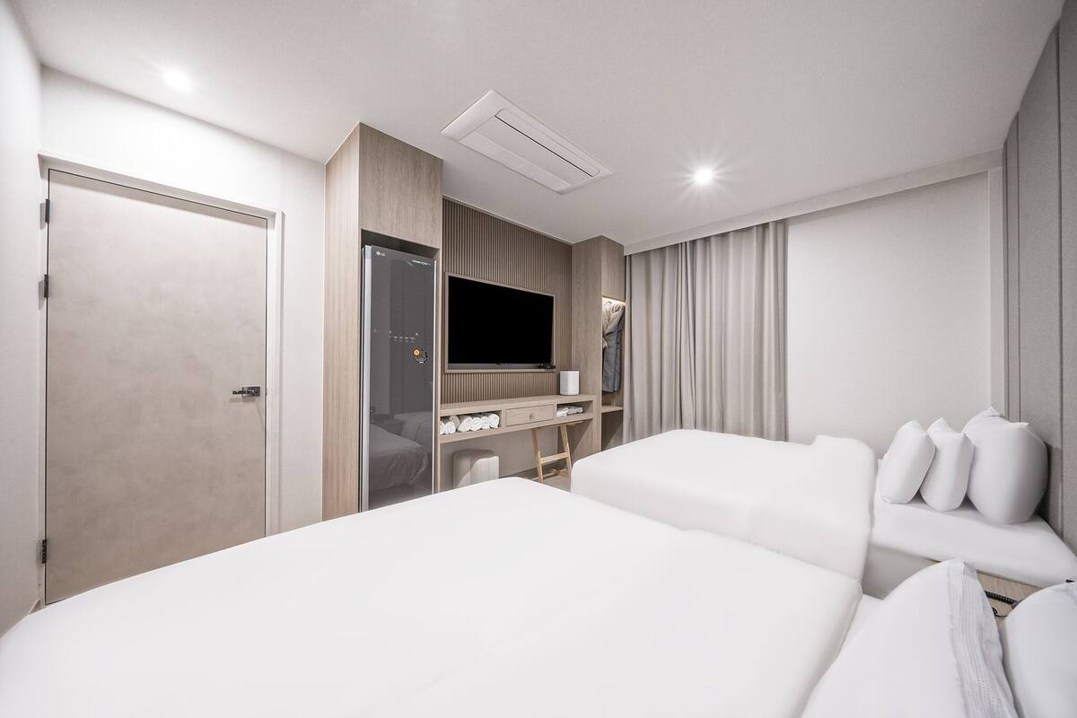 Een hotelkamer met een groot bed, een televisie, een bureau en een kledingkast.