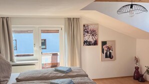A bedroom with two beds, a large window, and a view of the sea. - Apartment mit Bergblick (Aldrans)
