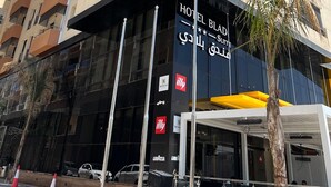 A multi-story hotel with balconies, a modern facade, and a sign indicating it is a hotel. - Bladi Suite Oran (Oran)