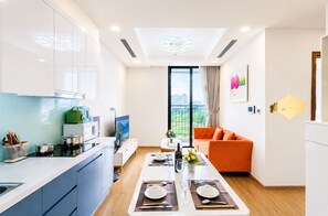 Una cocina moderna con zona de comedor, sofá y un amplio ventanal con vistas a la ciudad.