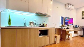 Een moderne keuken met houten kastjes, een inbouwspoelbak en een eethoek met een bank.