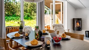 Un coin repas avec une table mise pour le petit-déjeuner, comprenant du pain, des œufs et des fruits.