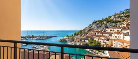 A coastal town with buildings, a marina, and a clear sky.