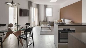 Una cocina moderna con comedor, horno integrado y un amplio ventanal.