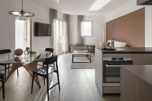 Eine moderne Küche mit Essbereich, einem eingebauten Backofen und einem großen Fenster.
