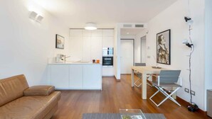 A modern apartment with a living room, kitchen, and dining area.