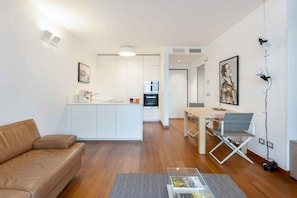 A modern apartment with a living room, kitchen, and dining area.