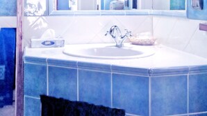 A bathroom with a large mirror, a sink, and blue tiles. - Villa Profidia (Gualdo Cattaneo)