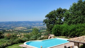 A swimming pool with a view of rolling hills and a clear sky. - Villa Profidia (Gualdo Cattaneo)