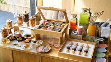 Una mesa de buffet con diferentes opciones de comida, bebidas y una estación de té.