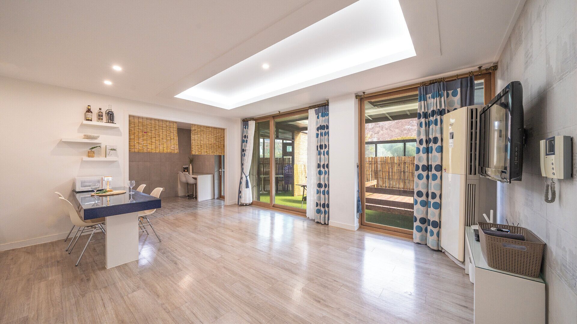A modern kitchen with a dining area, a built-in oven, and a large sliding glass door leading to an outdoor patio.