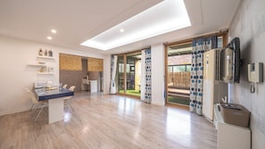 Une cuisine moderne avec un coin repas, un four encastré et une grande porte-fenêtre coulissante donnant sur un patio extérieur.