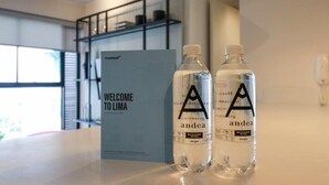 A reception area with a 'WELCOME TO LIMA' sign, two bottles of 'andea' water, and a glass on the counter. - w* | Perfect 1BR w/ Great Deco in Barranco (Barranco)