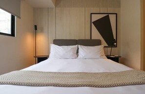 A hotel room with a large bed, two bedside tables, a wall-mounted artwork, and a window. - w* | Perfect 1BR w/ Great Deco in Barranco (Barranco)