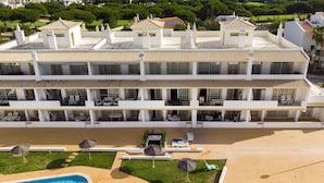 Un hôtel à plusieurs étages doté d’une piscine, d’un espace extérieur aménagé et d’une pelouse bien entretenue.