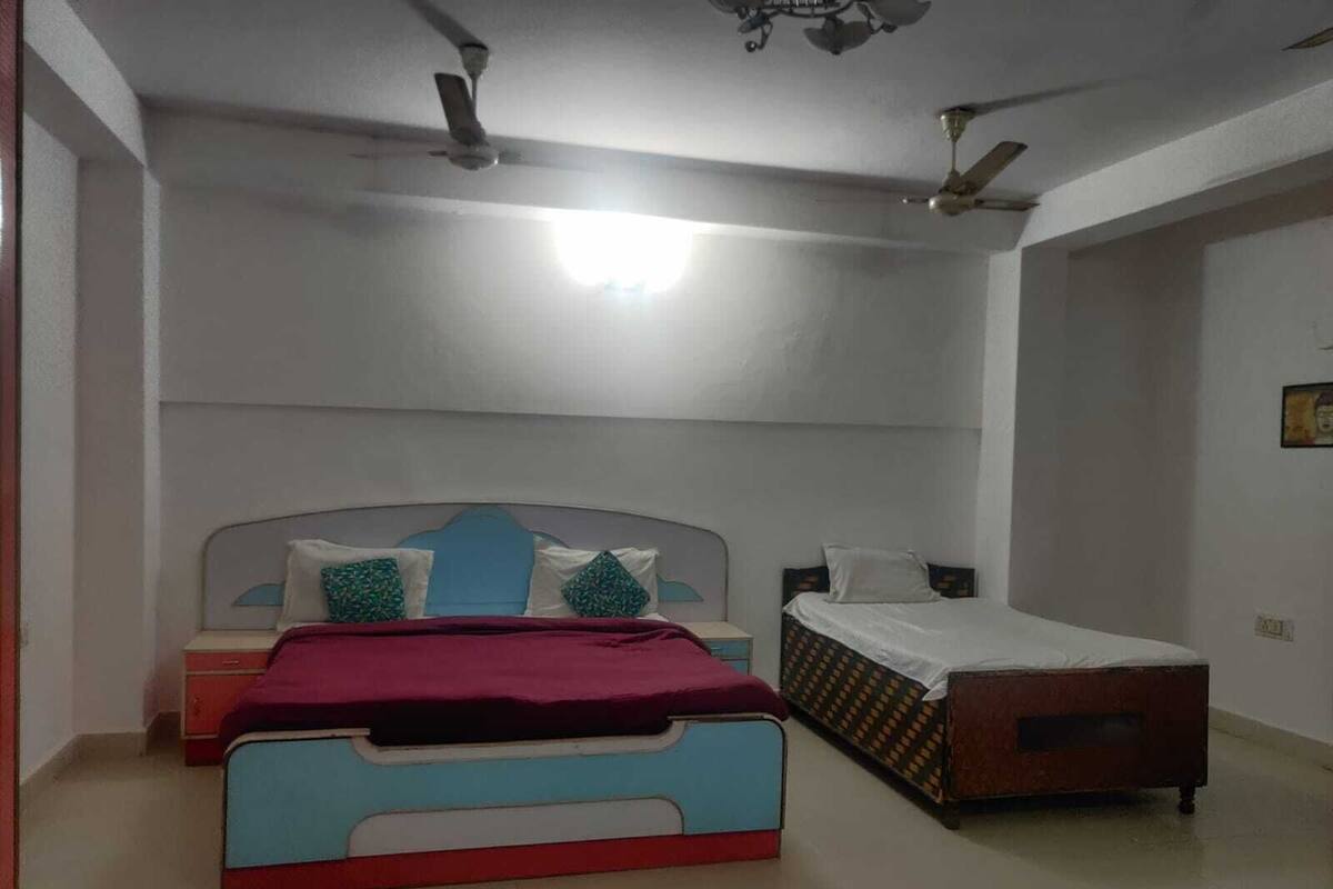 Un dormitorio con dos camas, ventilador de techo e iluminación.